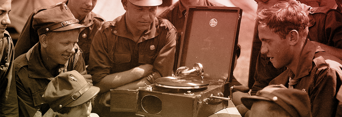 harcerze stoją wokół przenośnego gramofonu i ze skupieniem słuchają (1937 r.)