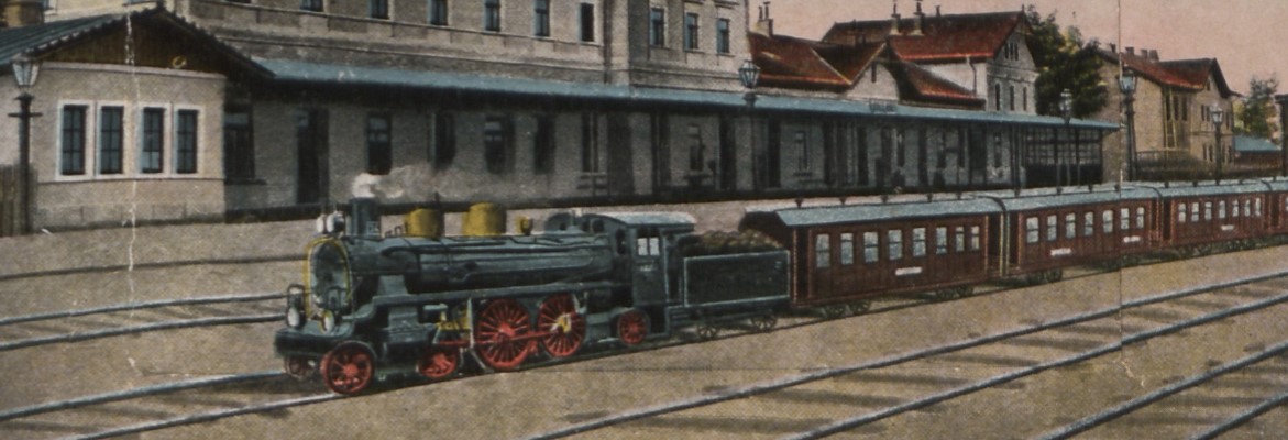 lokomotywa z wagonami na tle dworca w Samborze - fragment kolorowej pocztówki sprzed 1939 r.